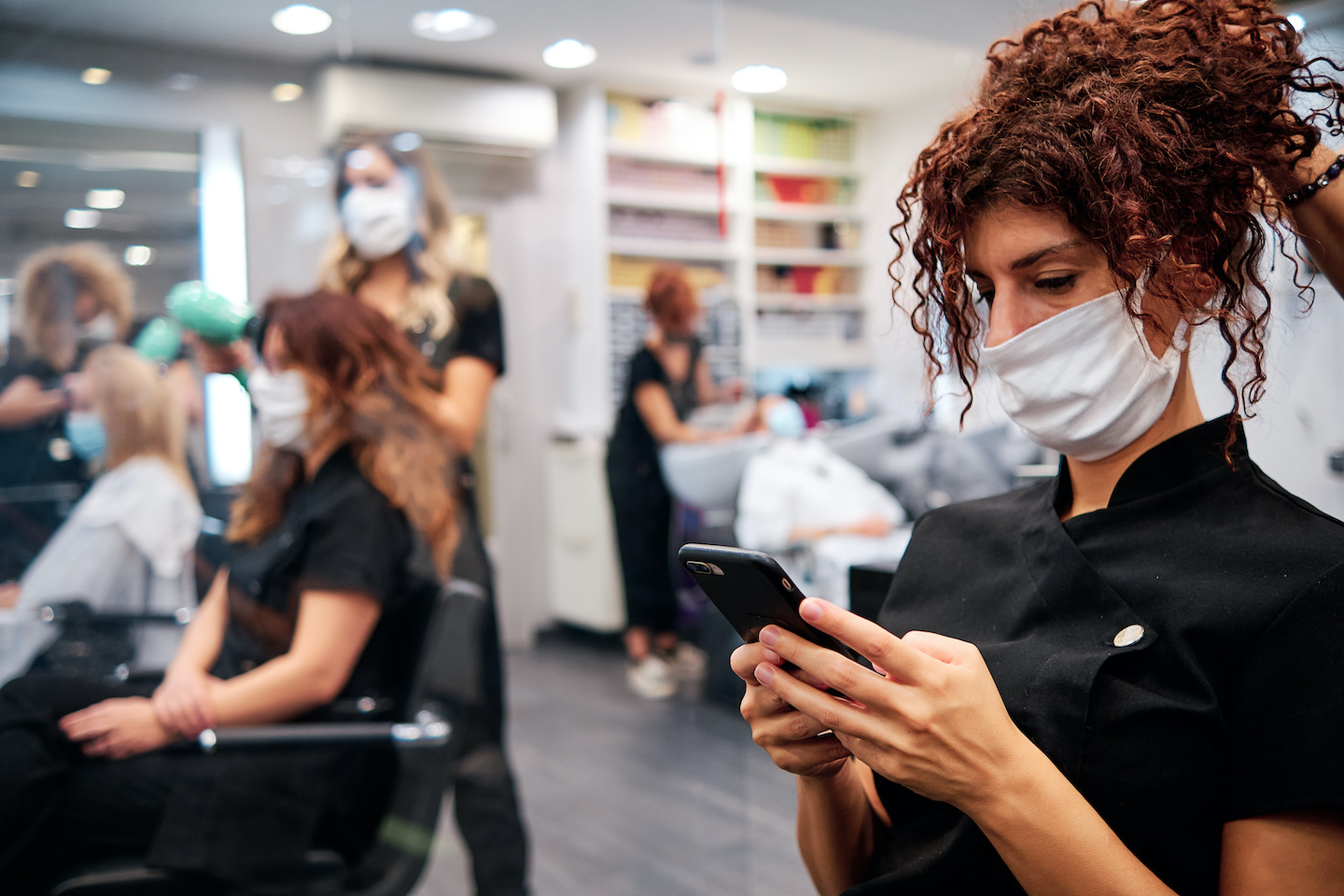 woman in hairdressing salon checking her mobile